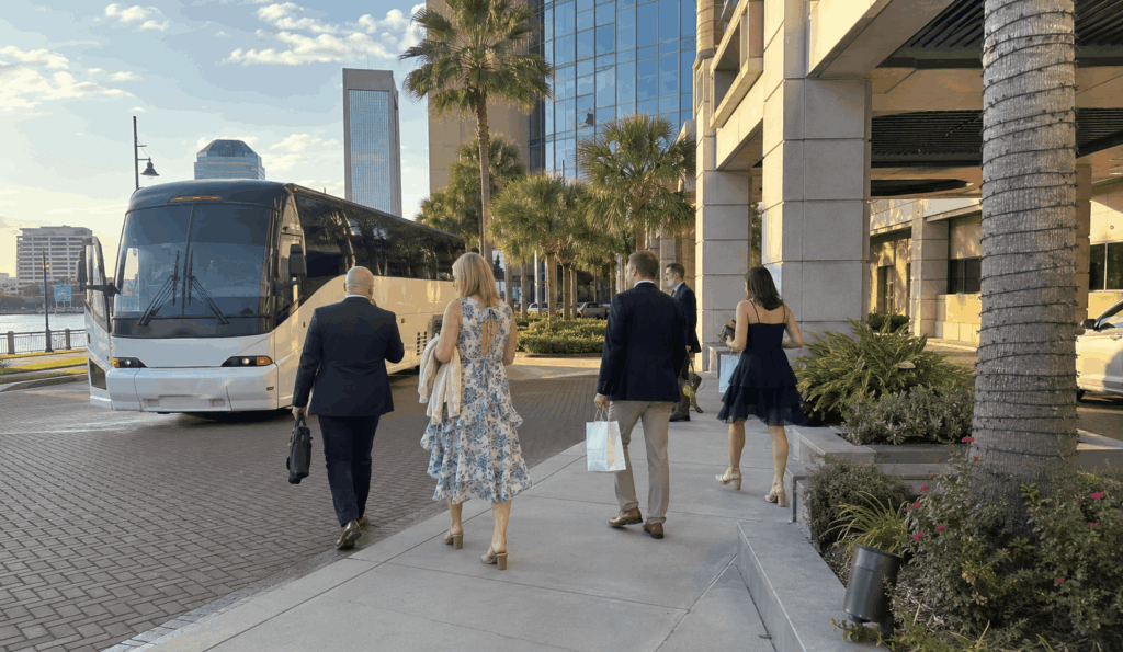 charter bus dropping off wedding guests near the wells fargo center lobby for a river club wedding in downtown jacksonville